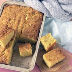 a loaf of bread sitting on top of a pan next to slices of cake in it