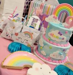 a table topped with lots of colorful cakes and rainbows on top of each cake