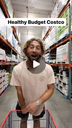 a man is standing in a grocery store with a shopping cart and has his mouth open