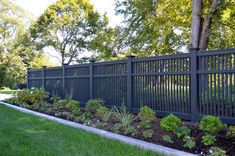 a black fence in the middle of a green yard