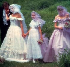 three women in wedding gowns standing next to each other