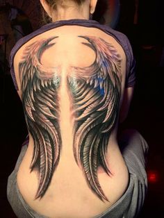 a woman's back with an angel wing tattoo on her upper and lower back