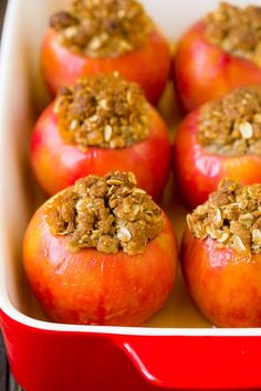 baked apples with granola in a red casserole dish