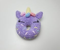 a purple stuffed animal with a unicorn horn on it's head and eyes closed