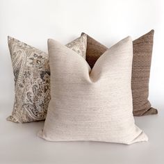 three decorative pillows on a white background