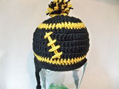 a crocheted hat with a football on the front and yellow stitching around the brim