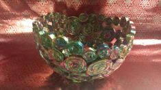 a glass vase sitting on top of a table covered in red and green swirls