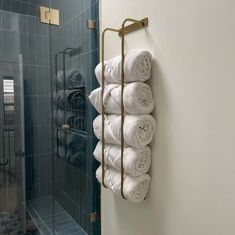 a towel rack is hanging on the wall next to a glass shower door in a bathroom