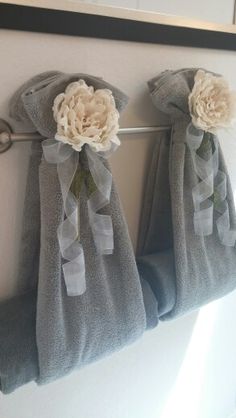 three towels hanging on a towel rack with flowers