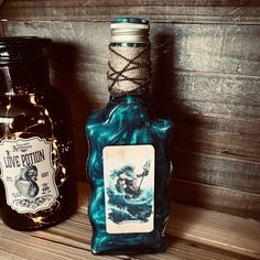 two bottles are sitting next to each other on a wooden shelf, one is blue and the other is black