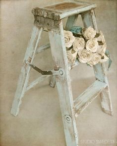 an old wooden step stool with flowers on it