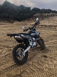 a dirt bike parked on top of a sandy beach