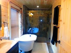 a bathroom with a tub, sink and shower in it