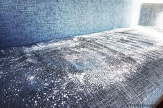 the bed is covered with white glitter and blue linens, as if it were made from an old mattress