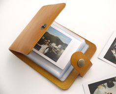 a wooden frame holding photos on top of a white table next to two polaroid frames