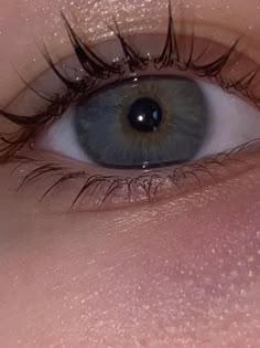 an eye with long lashes and blue eyes