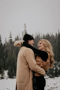 a man and woman are standing in the snow