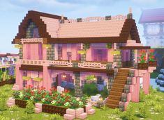 a pink house with lots of flowers in the front yard