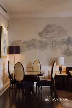 a dining room table with chairs and a painting on the wall