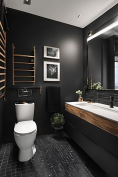 a black and white bathroom with wood accents on the vanity, toilet and sink area