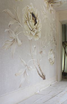 the wall paper has flowers on it and is painted with white paint in an elegant manner