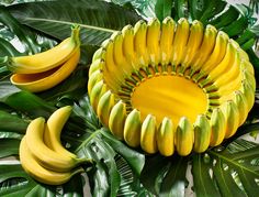 bananas and green leaves on a white surface