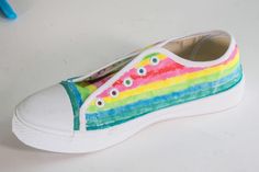 a pair of white shoes with rainbow painted on them