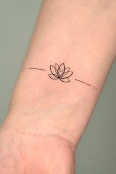 a small tattoo on the wrist of a woman's arm with a lotus flower