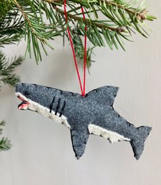 an ornament shaped like a shark hanging from a christmas tree