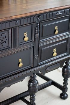 an old black dresser with brass pulls and knobs on it's drawers is seen in this image