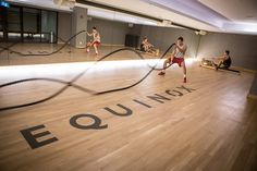 a group of people sitting on top of a wooden floor next to a sign that says equinncy