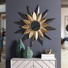 a decorative sunburst on the wall above a dresser