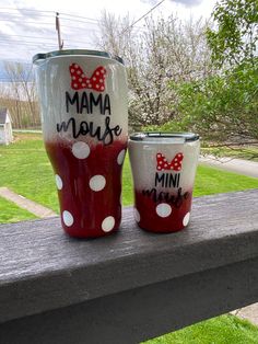 two red and white polka dot cups sitting on top of a wooden table next to each other