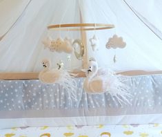 a baby crib with two white birds hanging from it