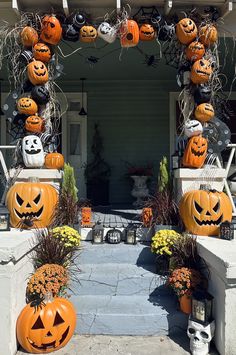 an entrance decorated for halloween with pumpkins and jack - o'- lanterns