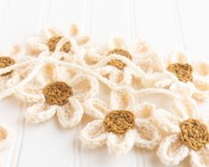 crocheted flowers are arranged on a white surface