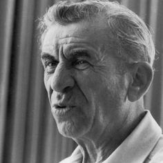 black and white photo of an older man looking off to the side in front of a curtain