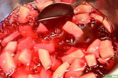 a pot filled with watermelon and sauce on top of a stove