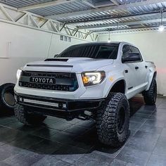 a white toyota truck parked in a garage