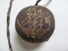 an old ball is sitting on the table next to a string that has been stitched into it