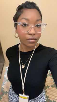 a woman with glasses and a name tag on her neck is posing for the camera