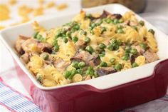 a casserole dish with peas and chicken in it on a tablecloth next to other dishes