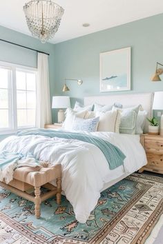 a large bed sitting in a bedroom next to a window with a chandelier