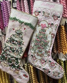 two christmas stockings are on display in front of some colorful ropes and other decorative items