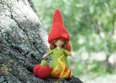 a little red haired doll sitting on top of a tree