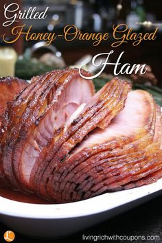 sliced orange glazed ham on a plate with the words grilled honey - orange glazed ham