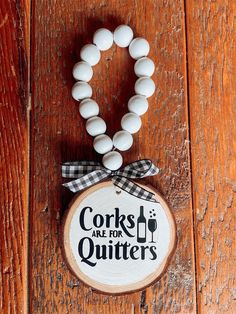 a wooden beaded bracelet with corks on it and a sign that says cooks are for quitters