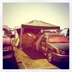 several cars are parked in front of a tent