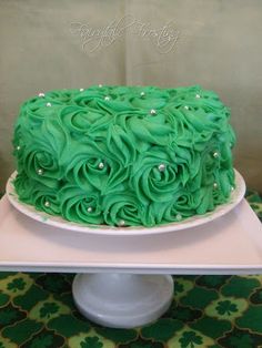 a green frosted cake sitting on top of a white plate