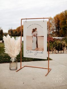 a sign with a photo on it next to a vase filled with pamodia